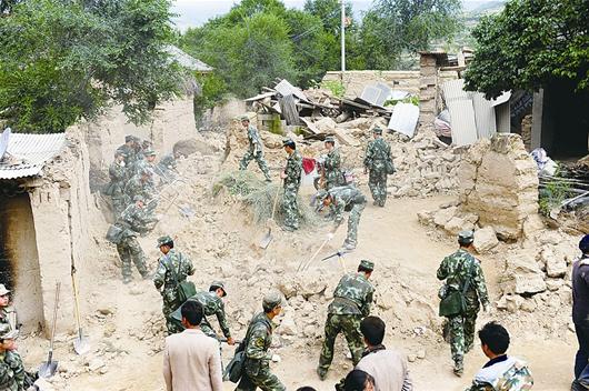 解放軍正站在幫助災(zāi)民清理廢墟